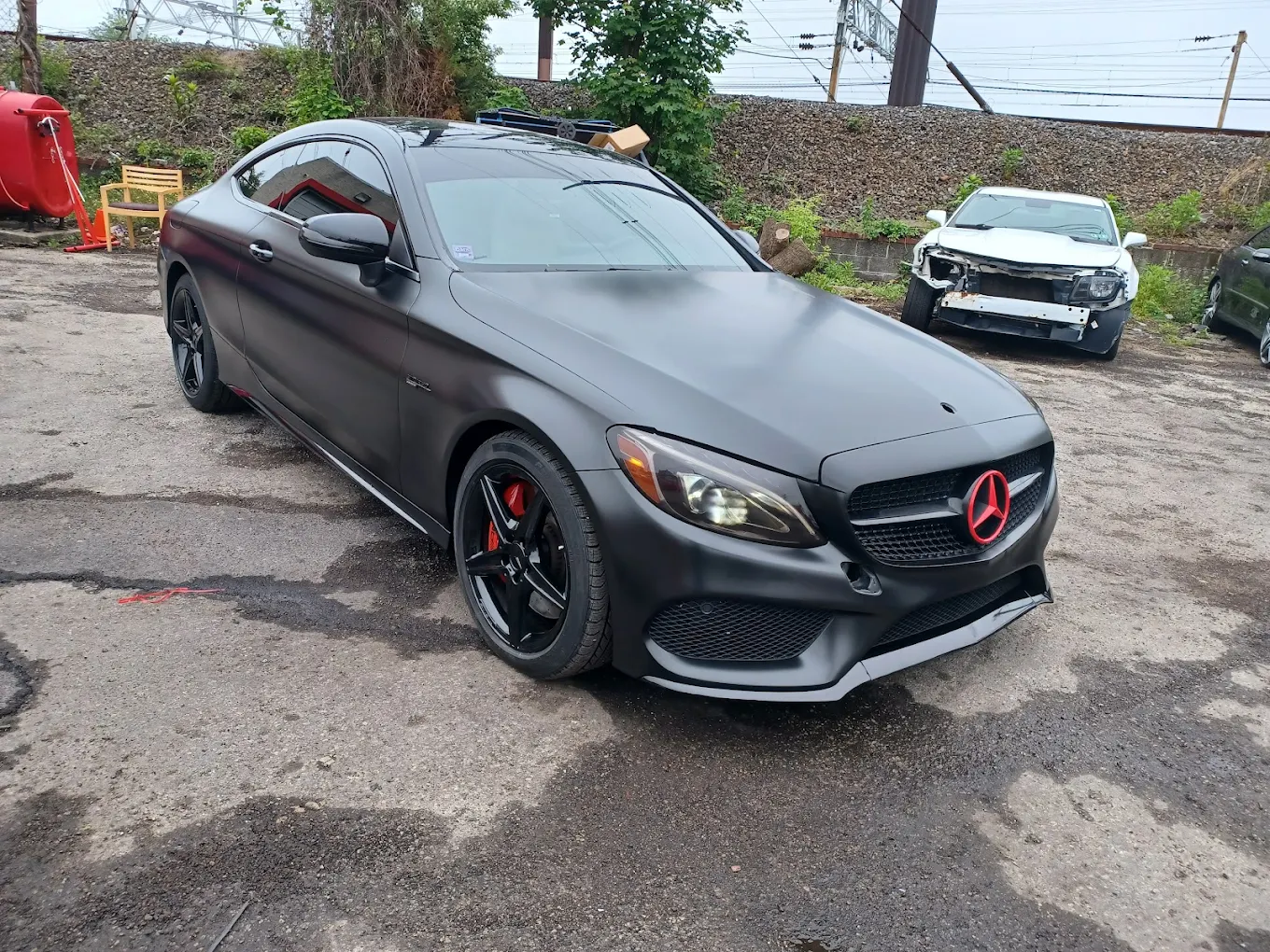 Matte black Mercedes coupe with red and black body accents